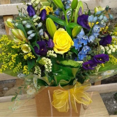 Sunshine and Blue flower box including lily - - Stunning handtied bouquet in yellow and blue/purple flowers. carefully arranged in a gift box.

(Please note this item is only available in our local delivery area. See our delivery page for more information).

£40.00 - standard (As shown in image)

hand delivered in one of of best selling flowers boxes, this is a perfect gift for someone who loves flowers but doesnt like to arrange them in a vase, simply top up with water every few days and enjoy for weeks. 

We recomend all our fresh flower bouquets and arragements are kept away from strong sunlight and heat to esure the maxium life at home.

This bouquet may not always be availble for same day delivery so please allow a 48 hours notice or contact the shop on 01547 528786 before ordering if you require this exact bouquet. 

due to the nature of flowers, Tanith our florist and Flower Box owner may sometimes feel it neccesary to subsitute certain flowers in a bouquet but the colours and value of the design will remain the same, on the rare occasions this is required you will alwasy receive a phone call or email before we go ahead with the order. 

Each and every order is photographed before leaving the shop and a copy of this will be sent to your email provided during checkout after delivery is completed.