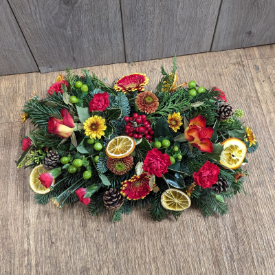 Golden Christmas Table Decoration - Golden Christmas Table Decoration-
Carefully selected Christmas flowers surrounded by beautiful Christmas foliage. with scented dried citrus slices and pine cones, Available with or without candle decoration.
A perfect talking point for any Christmas table. 
Simply top up with water every few days. Keep away form direct heat and light.