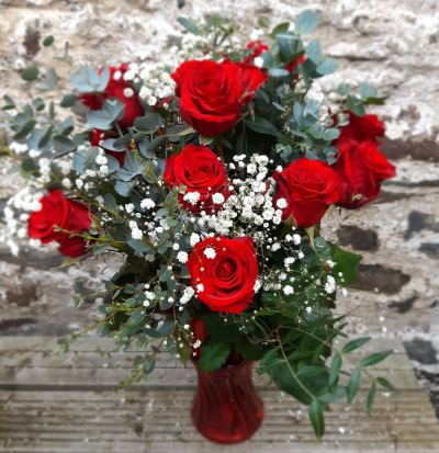 Classic Dozen red roses in vase - A dozen red roses, with gypsophila flower surrounded by  beautiful green shades of foliage presented in a gift vase.